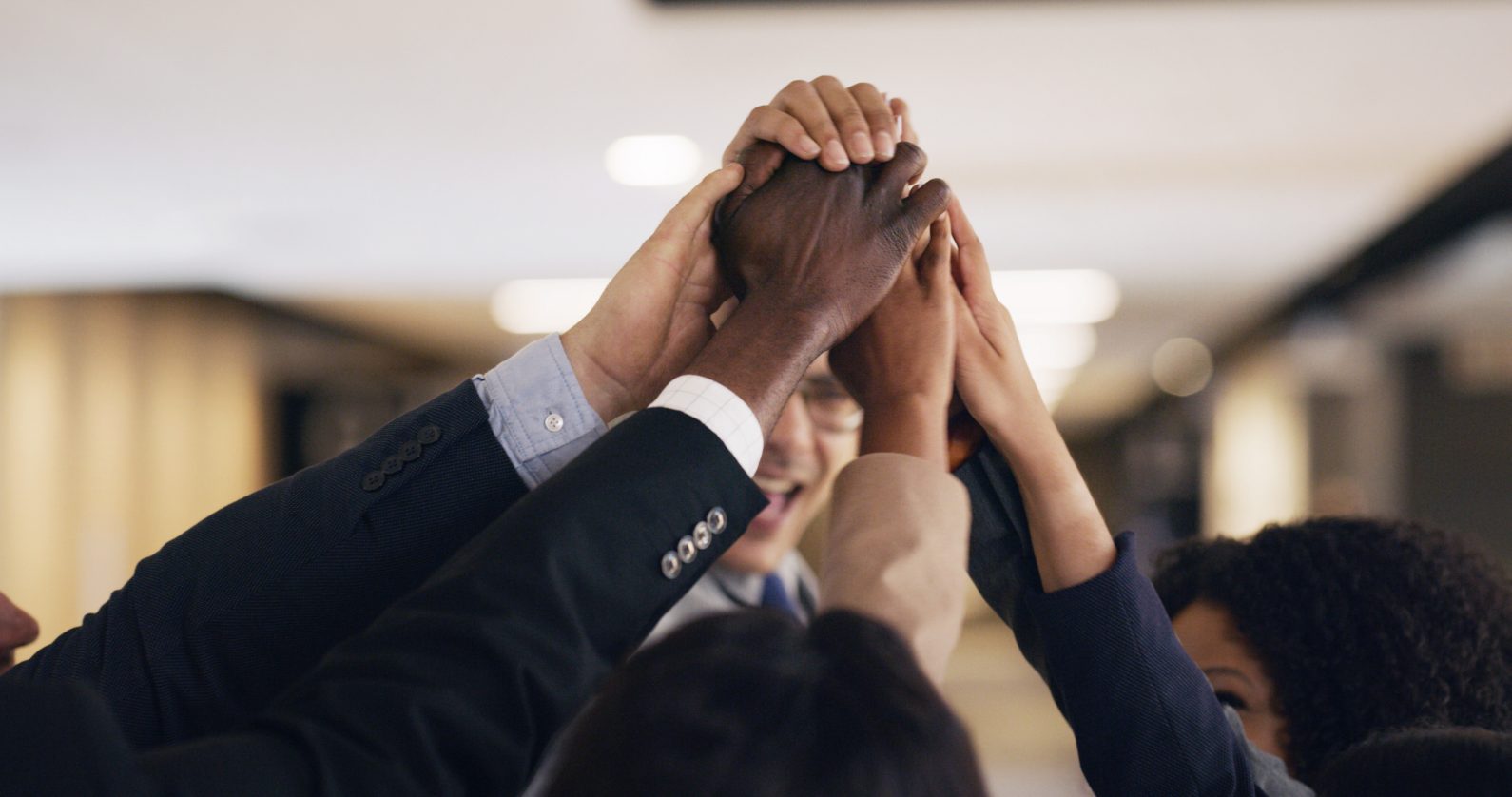 Team members joining hands in a huddle