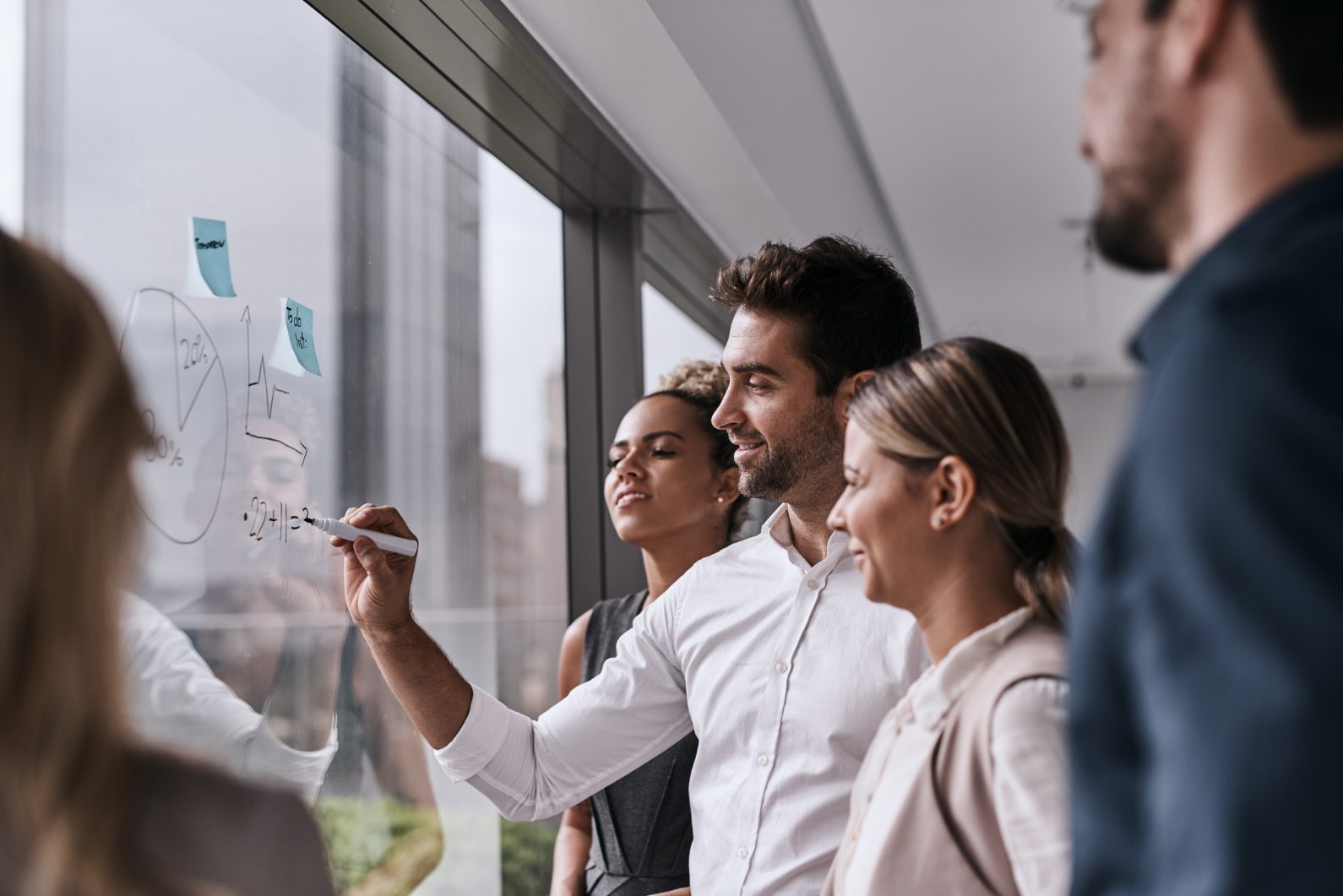 Mosaic consultants sketching a solution on a glass wall