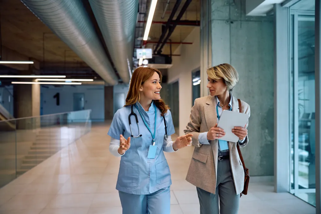 A nurse and a hospital administrator talking in a corridor