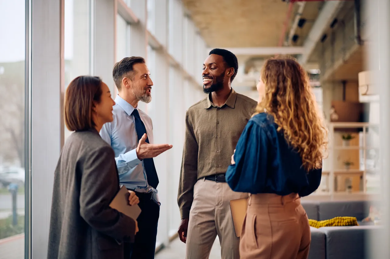 Four colleagues talking together in an office walkway
