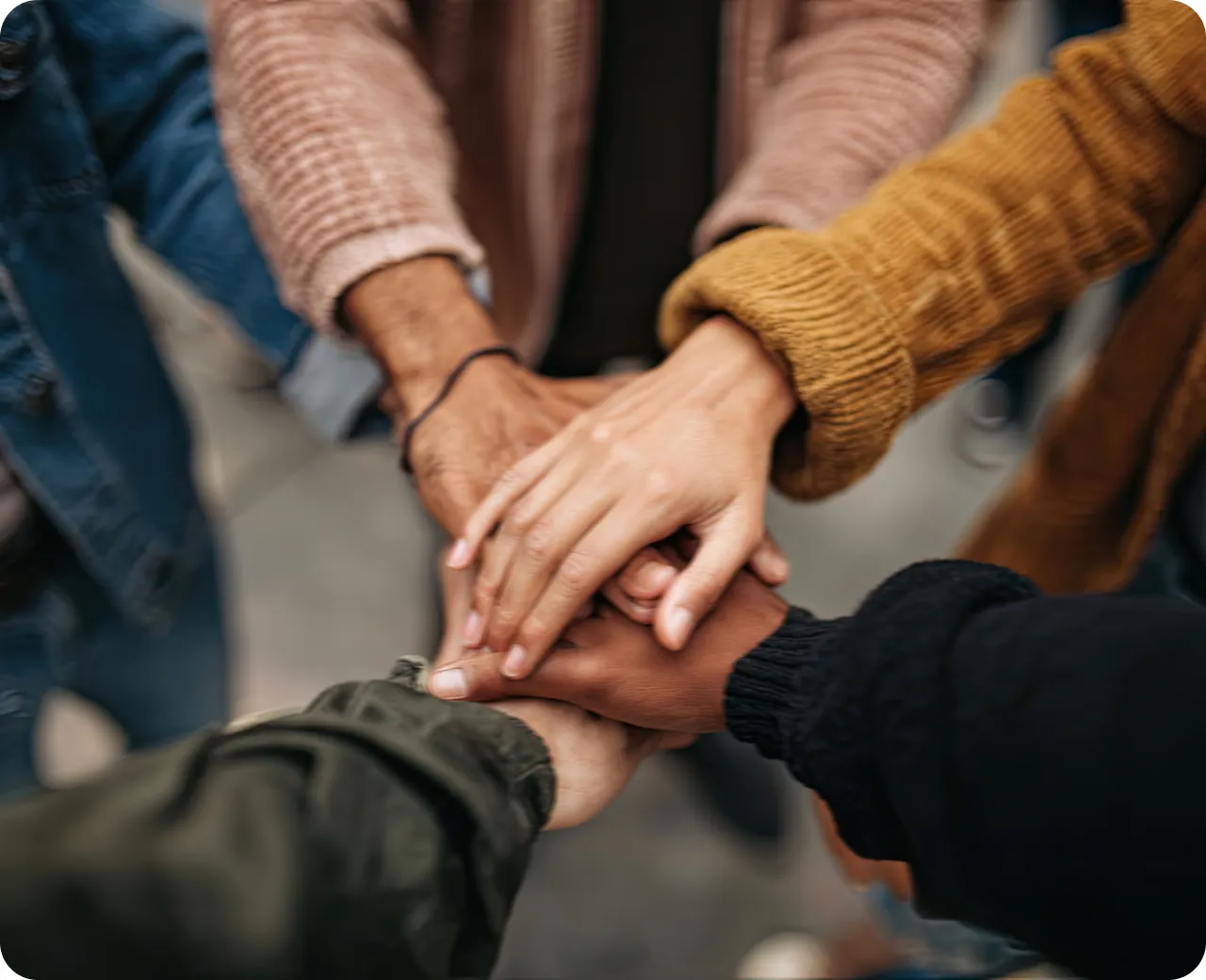 Colleagues stacking their hands together in a team huddle